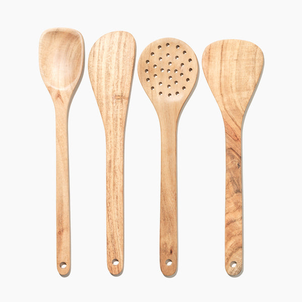 Set of four wooden cooking utensils on a white background