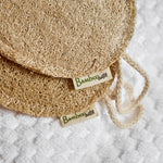 Two natural loofah sponges with 'Bamboo Switch' labels on a white textured background.